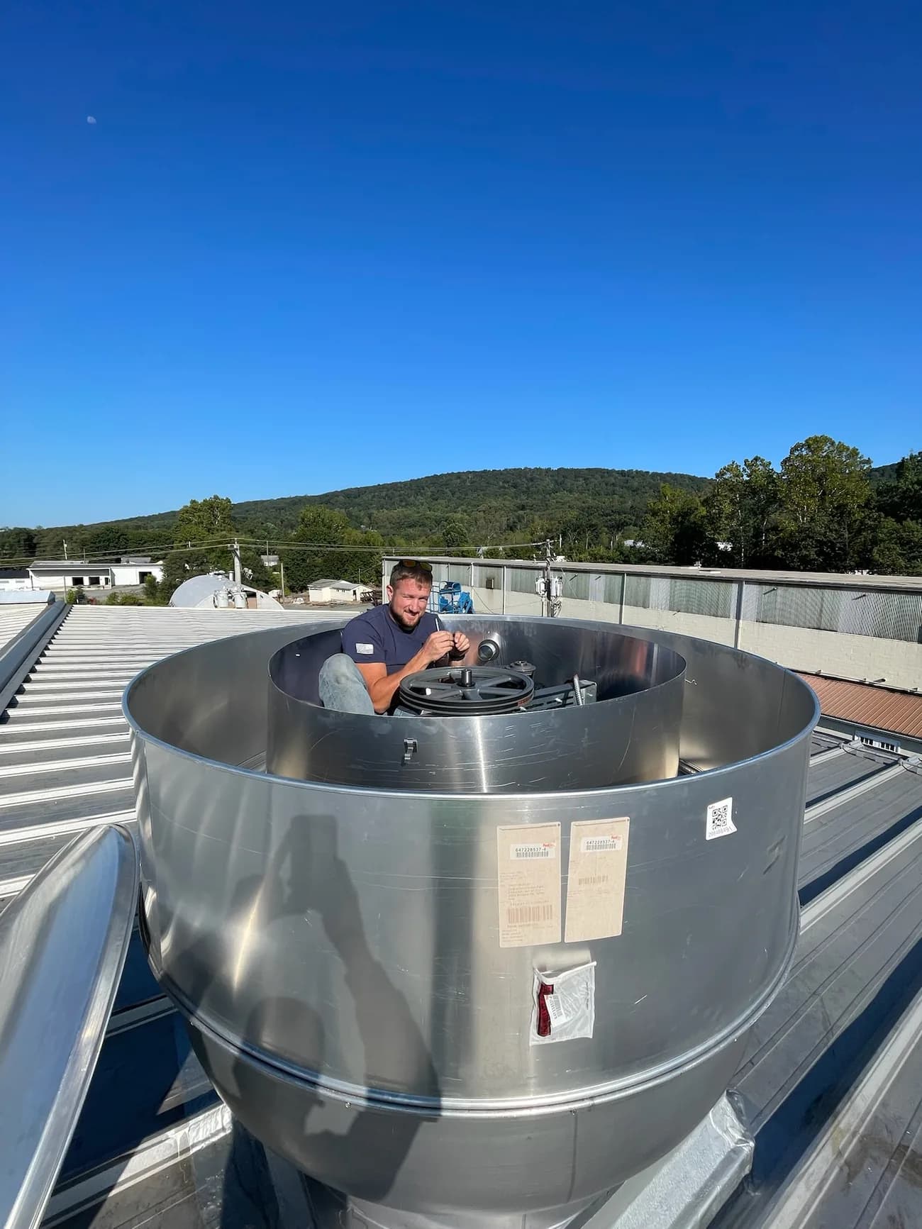 Slon Electric electrician working on a rooftop exhaust fan