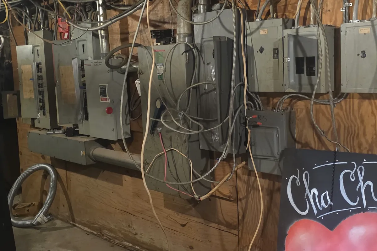 Row of older electrical panels along a farm building wall