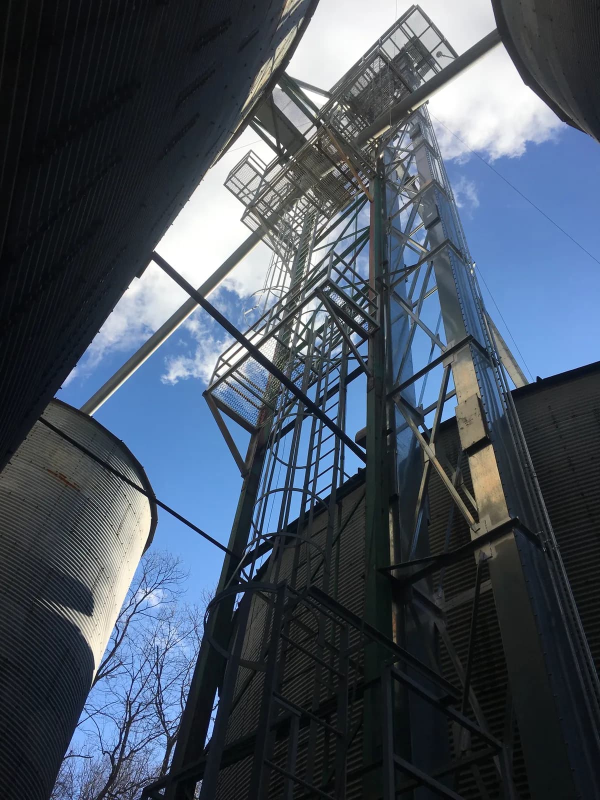 Grain bin and elevator leg against the sky