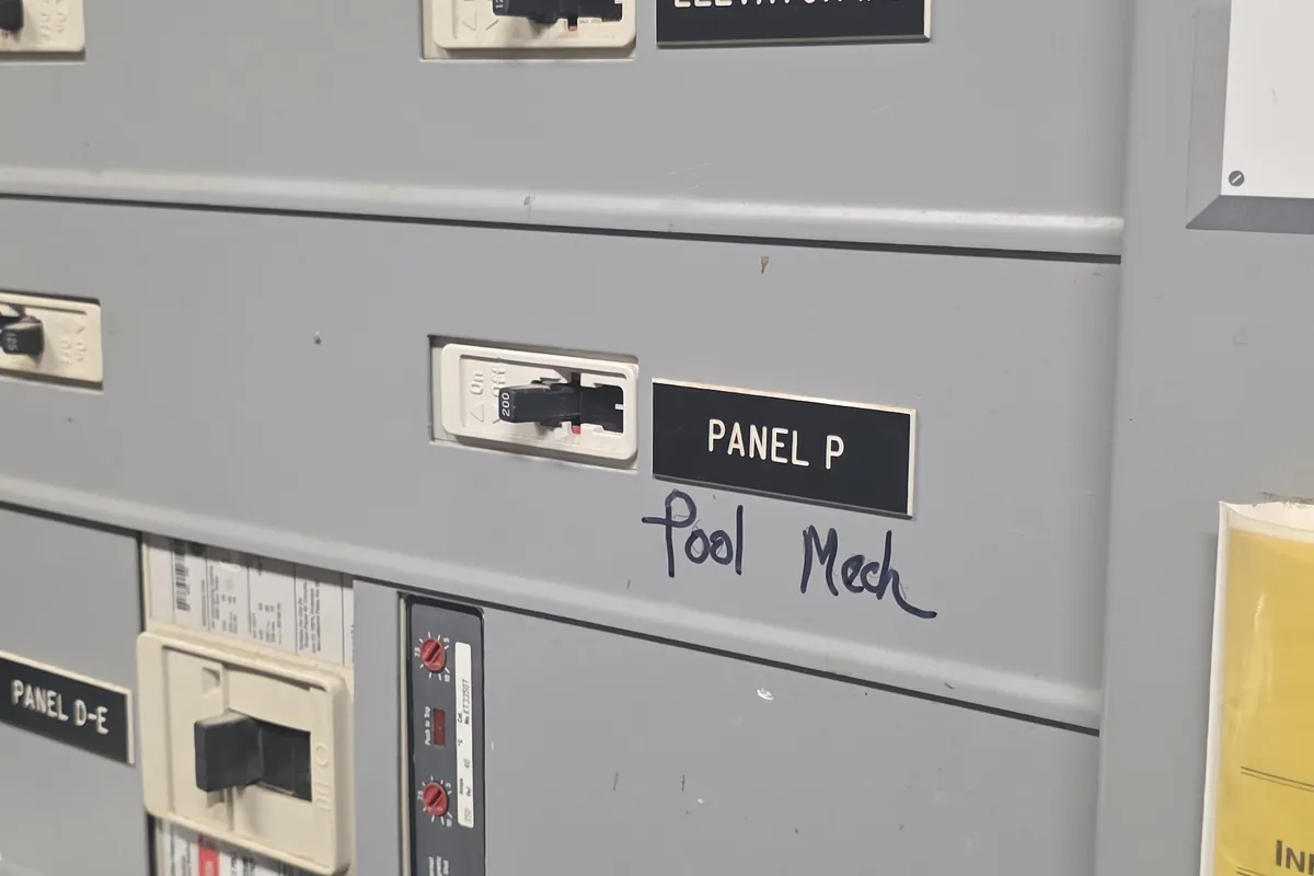 Electrical room with a lineup of labelled panels including the elevator supply