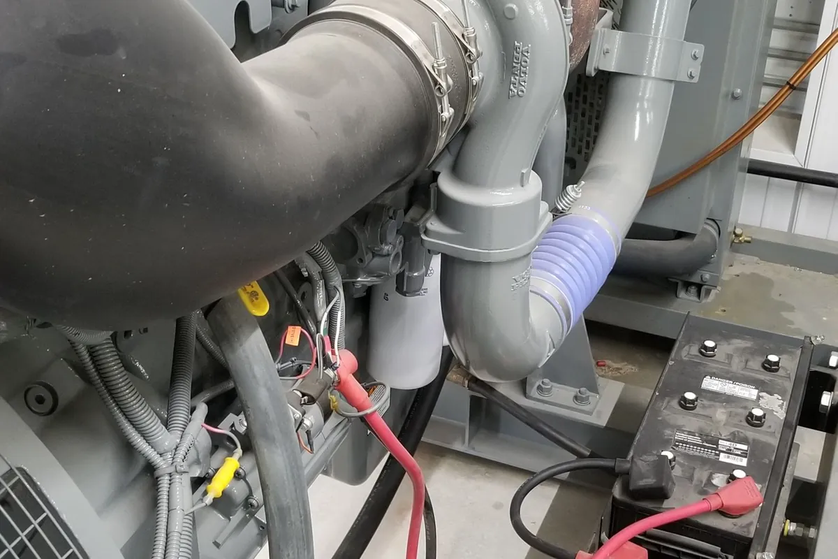 Diesel generator set with batteries and exhaust connected in a farm generator room